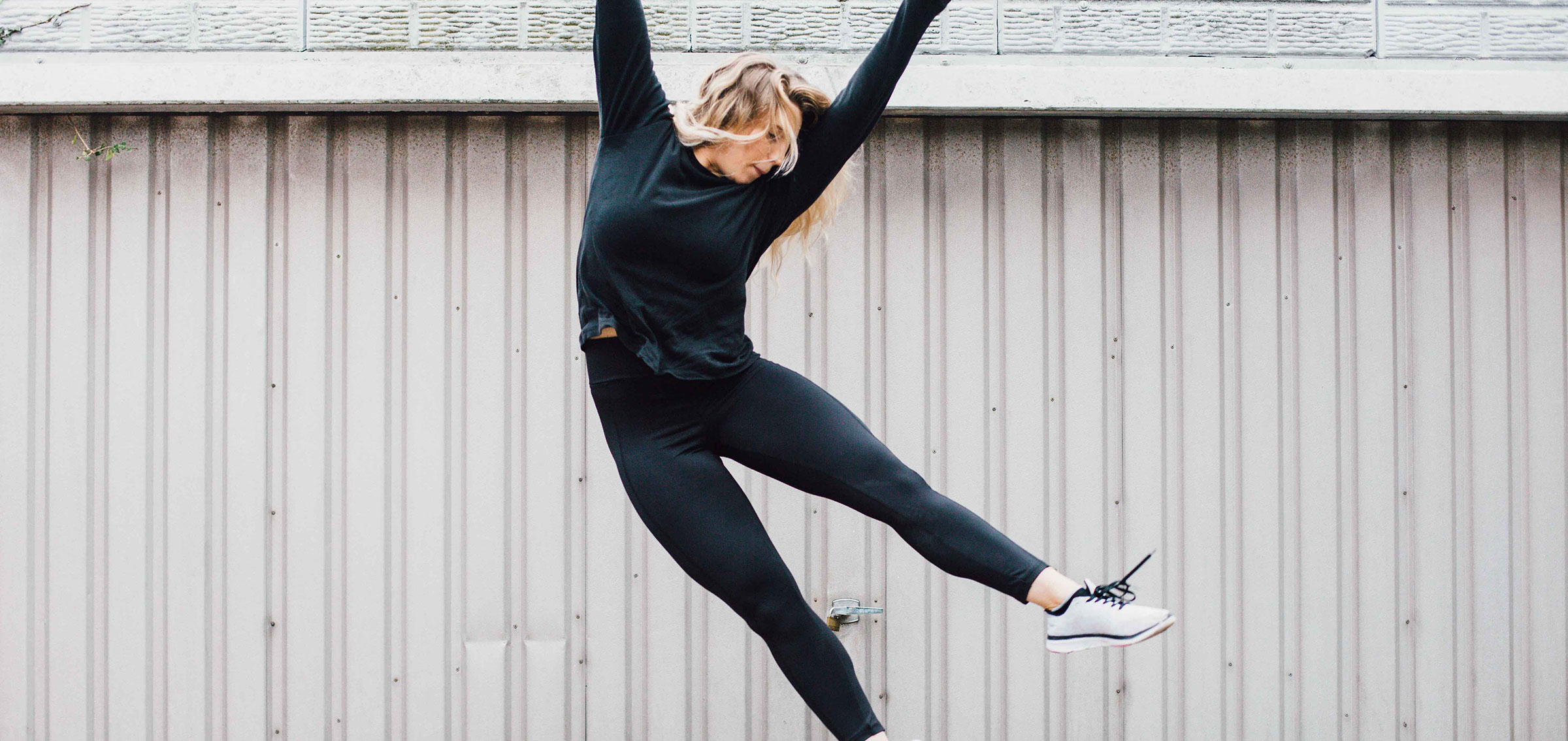 Phoebe Kay Jumping in front of a garage